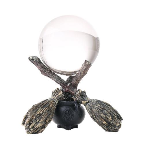 Crystal ball on a decorative stand with branches and brooms.