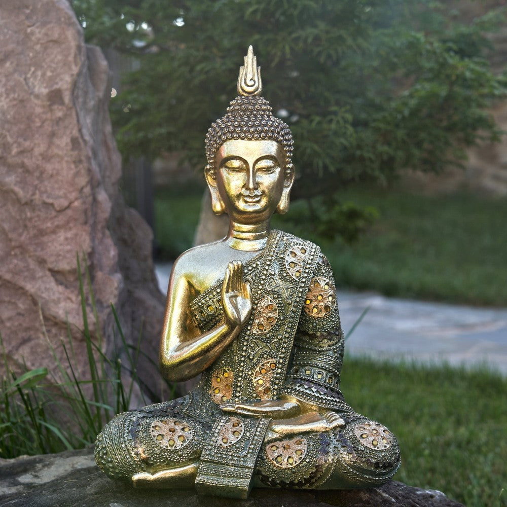 Golden Buddha statue in a peaceful garden setting.