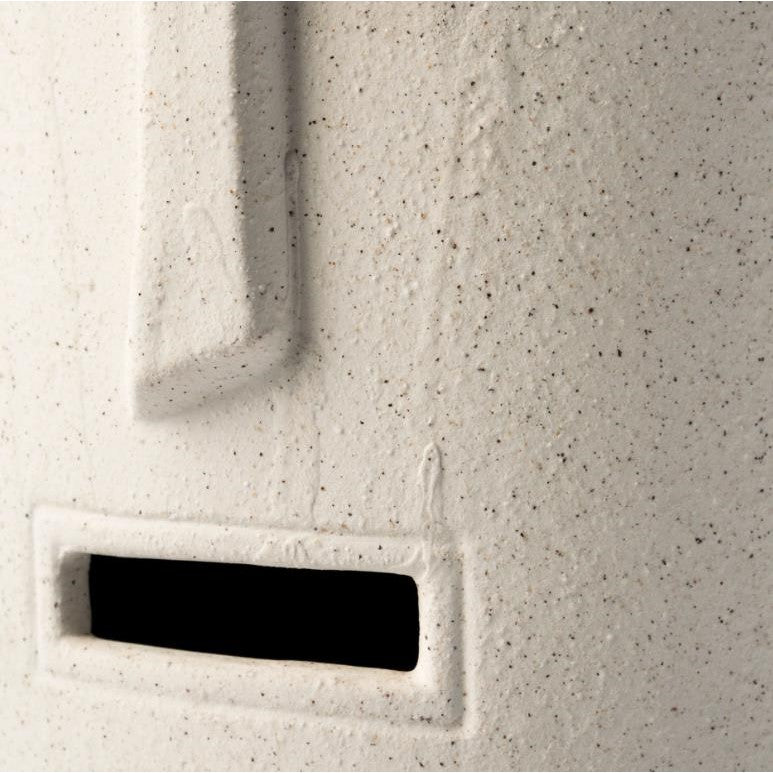 Close-up of a textured, speckled ceramic object with rectangular cutout.