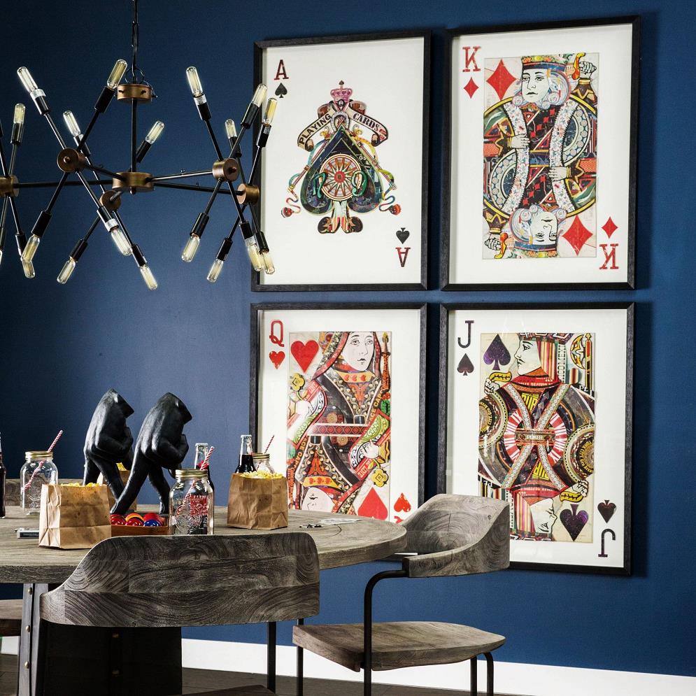 Dining room with card-themed art and a modern chandelier.