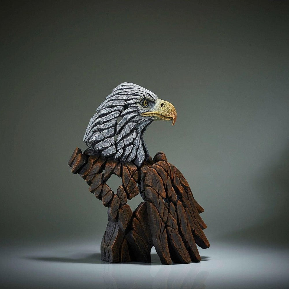 Sculpted eagle made of textured, stacked stones against a soft background.