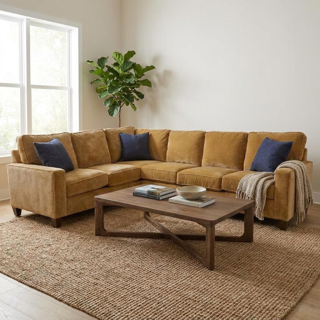 Cozy living room with tan sectional, blue pillows, and wooden coffee table.