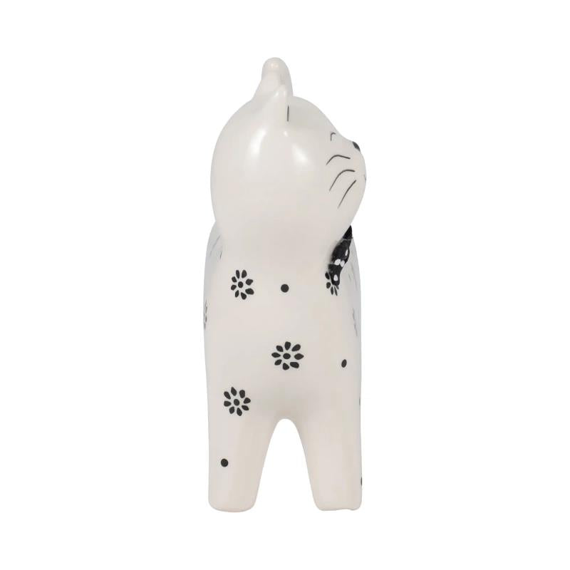 White cat figurine with black floral patterns.