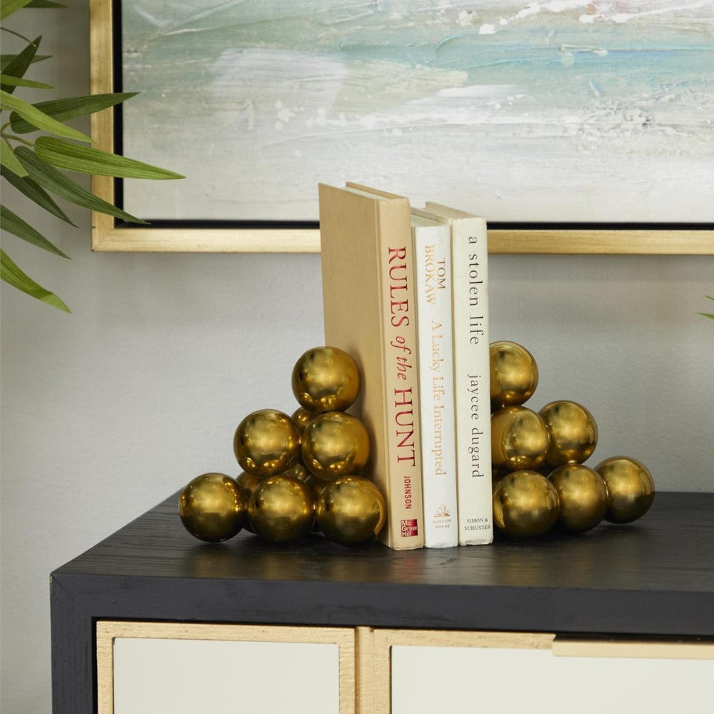 Books with gold sphere bookends on a black shelf.