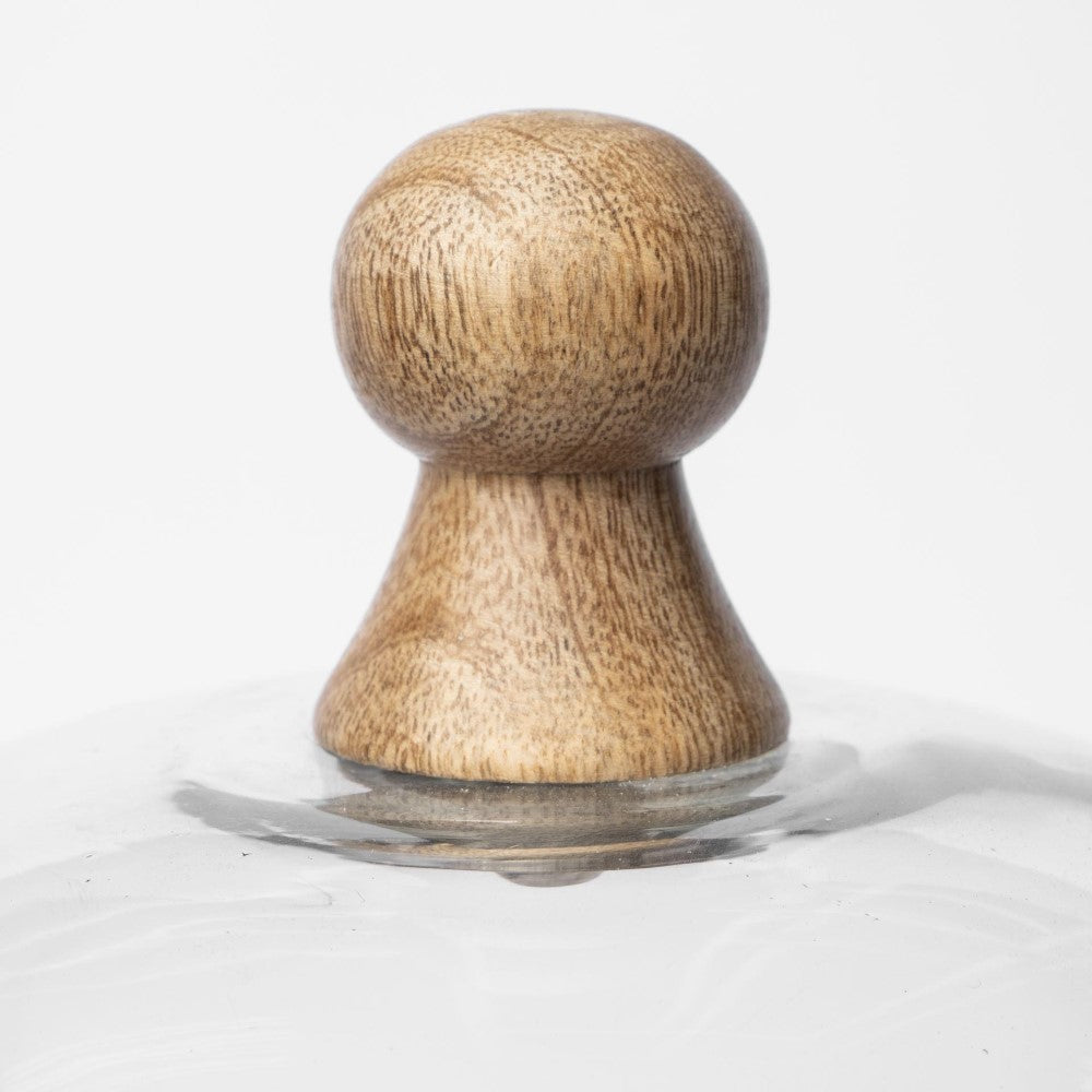 Wooden knob on a clear glass base, white background.