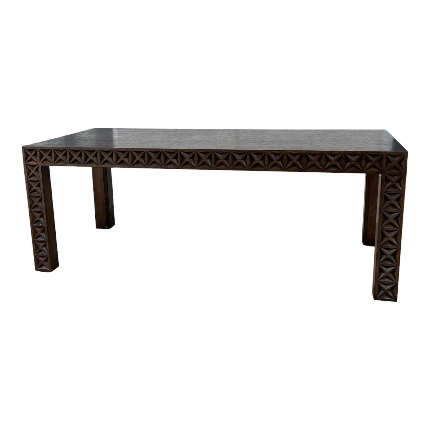 Dark wooden table with geometric carved edges.