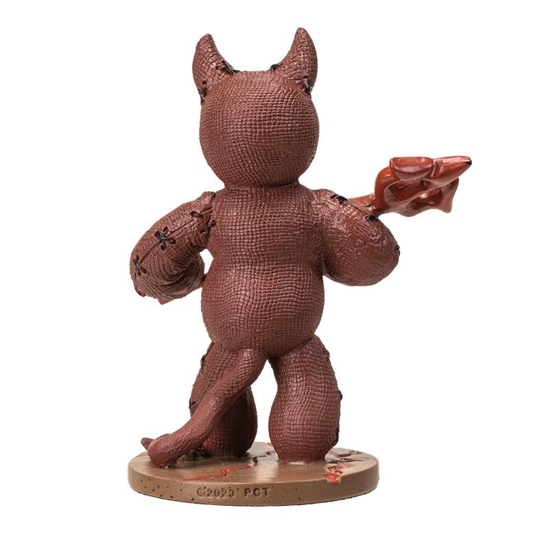 Brown, textured devil figure with horns, holding a fork, standing on a base.