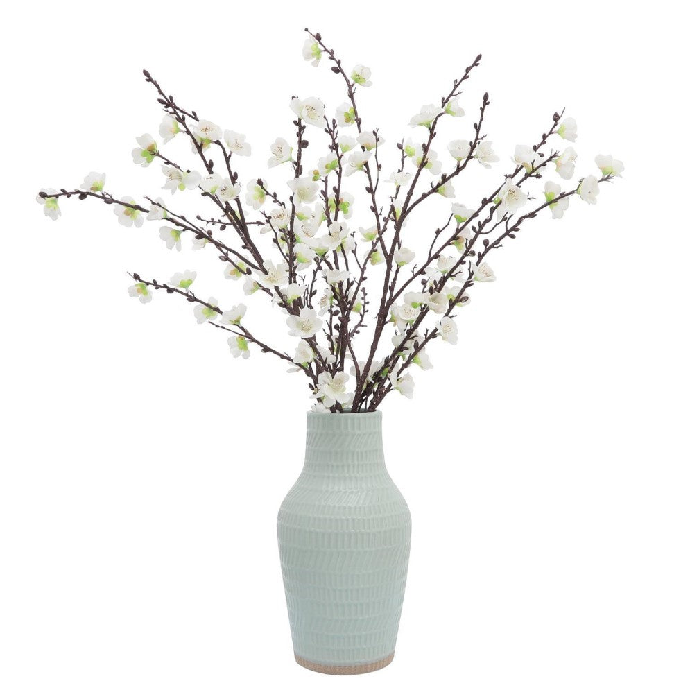 White blossoms in a textured vase.