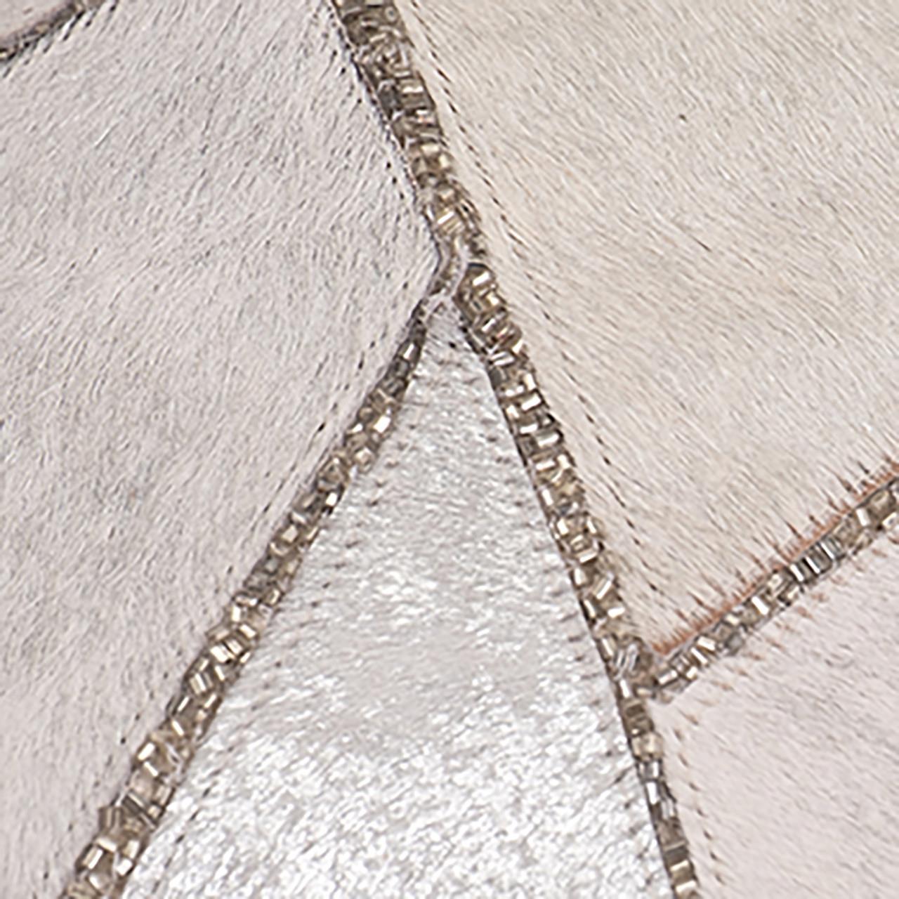 Abstract patchwork with shimmering silver and textured white fabric.