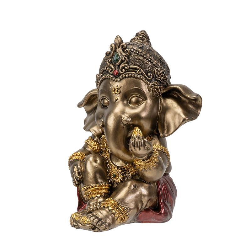 Golden Ganesh statue adorned with intricate details, sitting and eating.