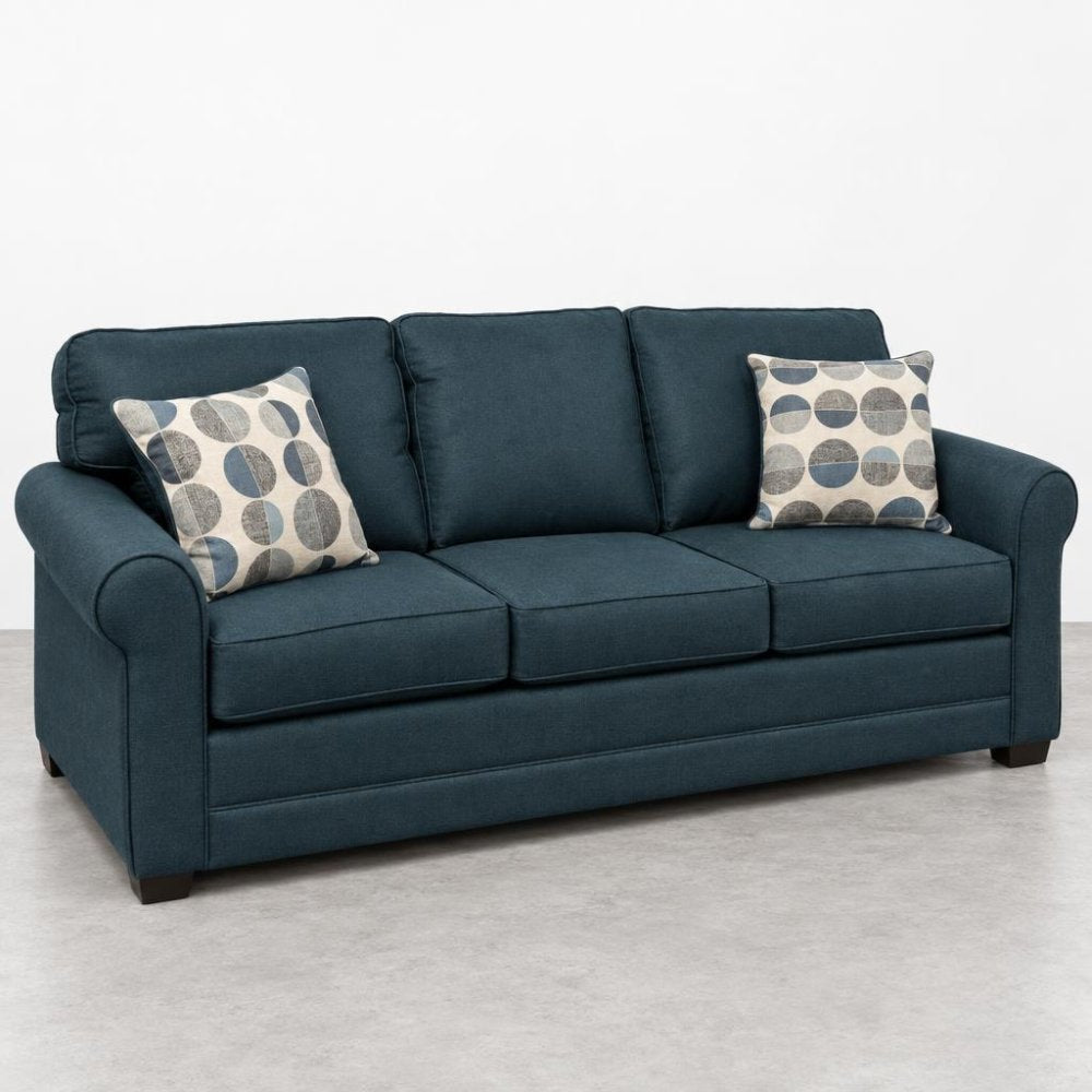 Dark blue sofa with patterned pillows, on a light floor.