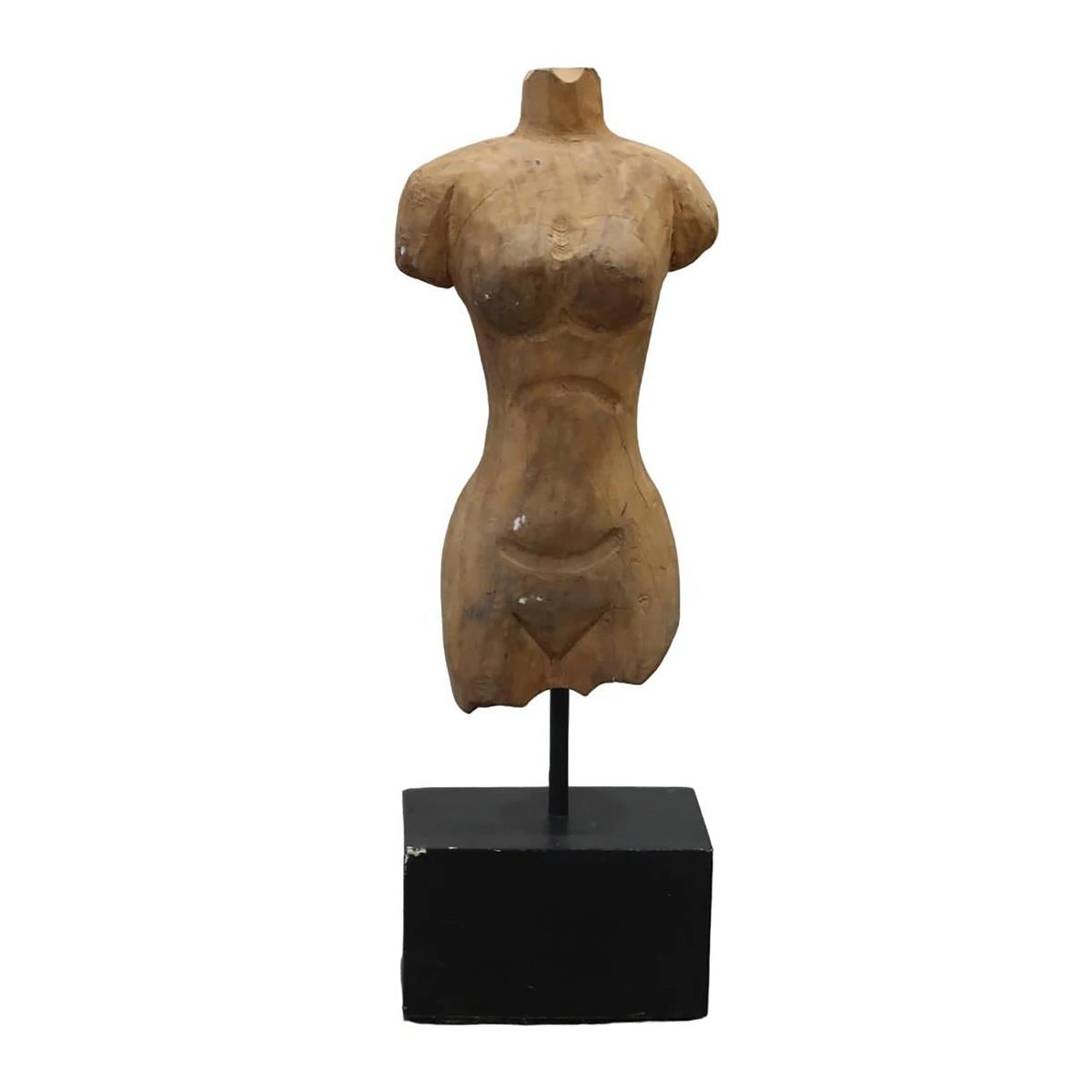 Wooden torso sculpture on a black stand.