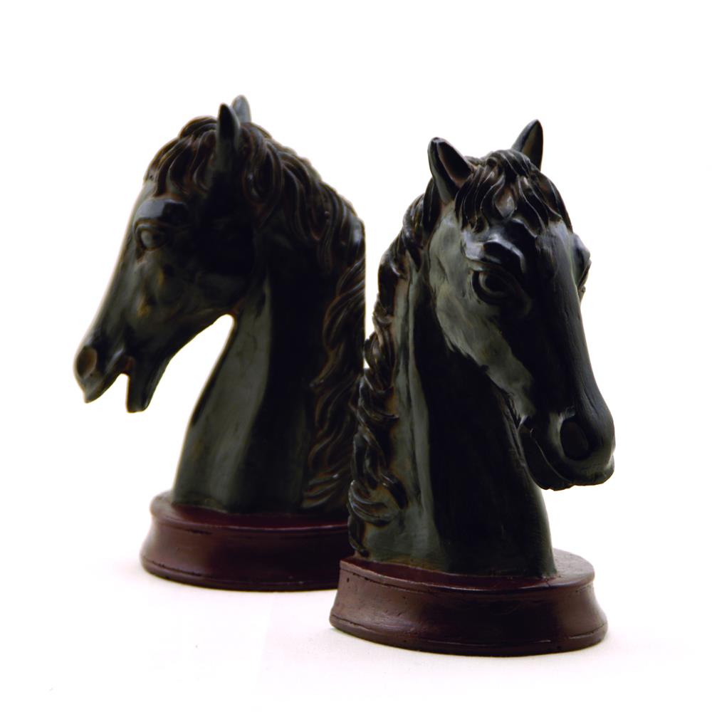 Two horse head sculptures on wooden bases.