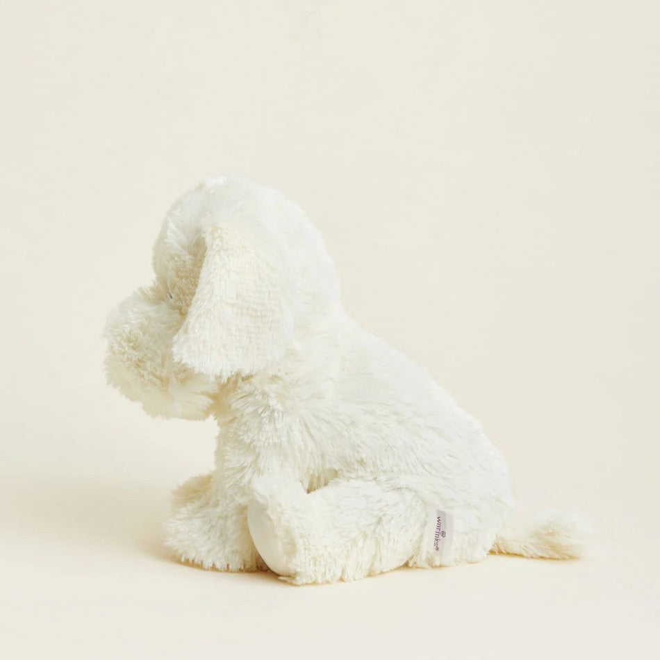 Fluffy white stuffed dog, sitting profile on a pastel background.