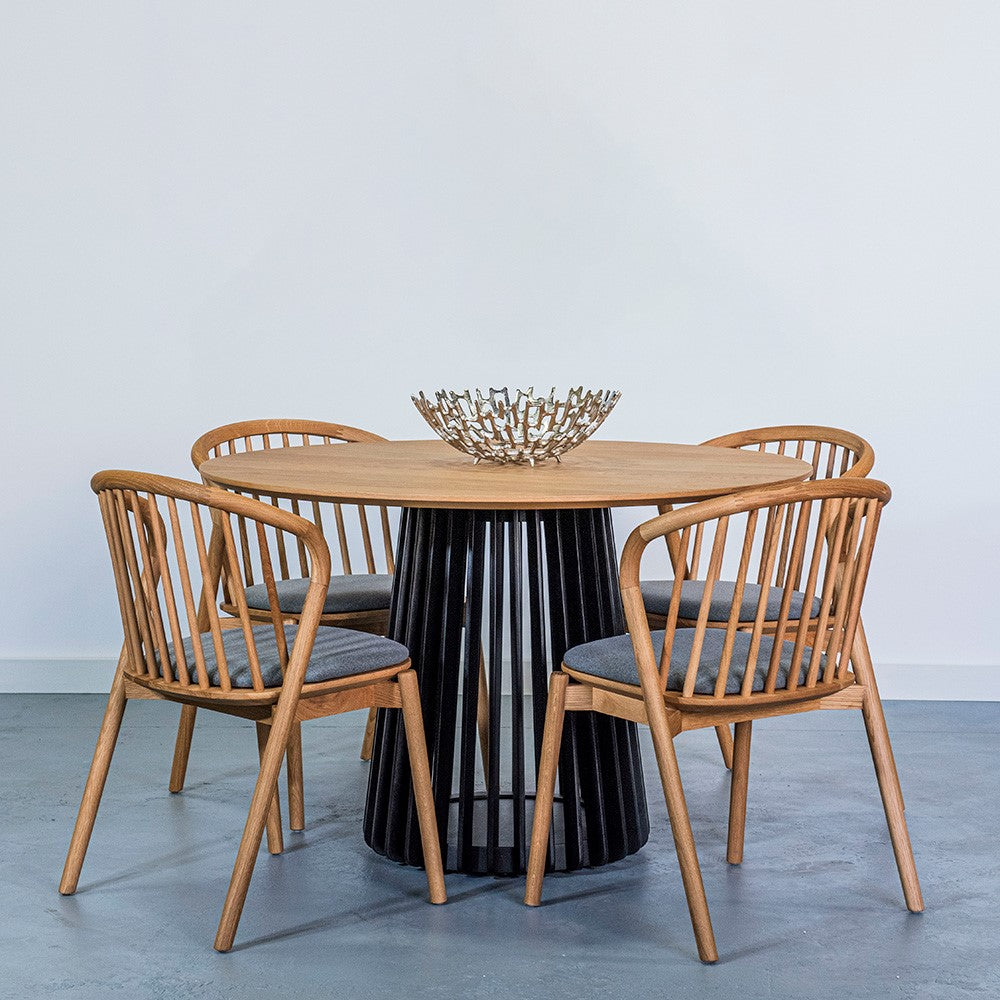 Wooden dining set with modern chairs and artistic centerpiece in a minimalist room.