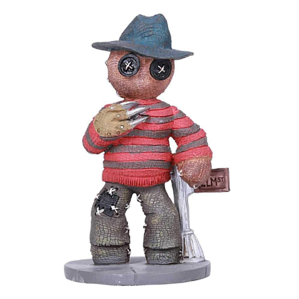 Patchwork figure with hat, button eyes, claws, striped shirt, and street sign.