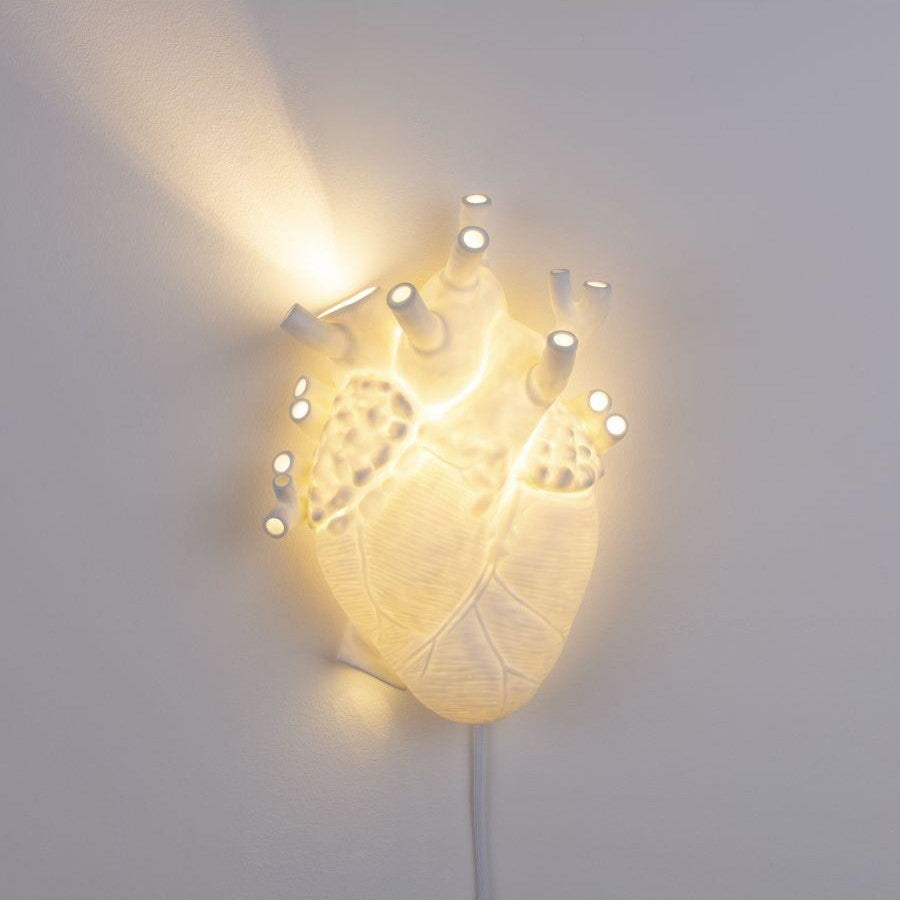 Heart-shaped wall lamp emitting warm light.