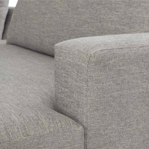 Close-up of a gray upholstered sofa armrest.