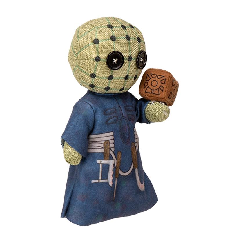 Cute plush doll with button eyes and detailed blue outfit holding a carved brown cube.