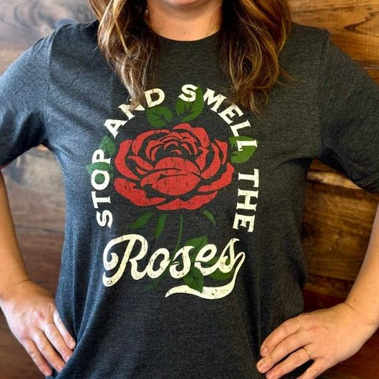 Person wearing a "Stop and Smell the Roses" T-shirt.