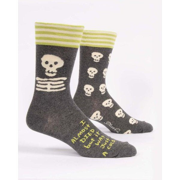 Gray socks with skulls, stripes, and humorous text.