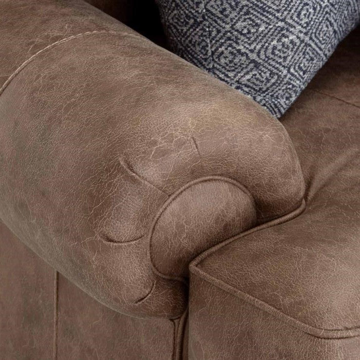 Brown leather couch arm with textured cushion.