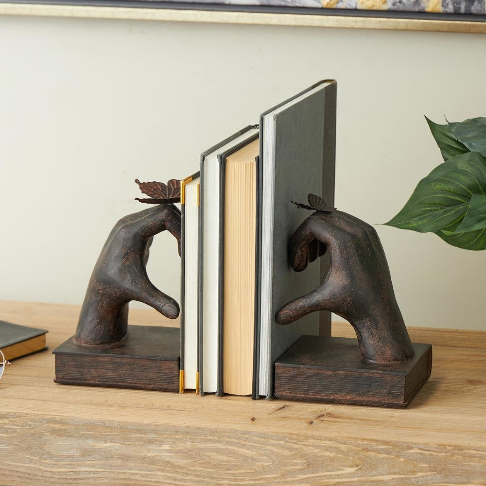 Bookends shaped like hands with butterflies holding books upright.