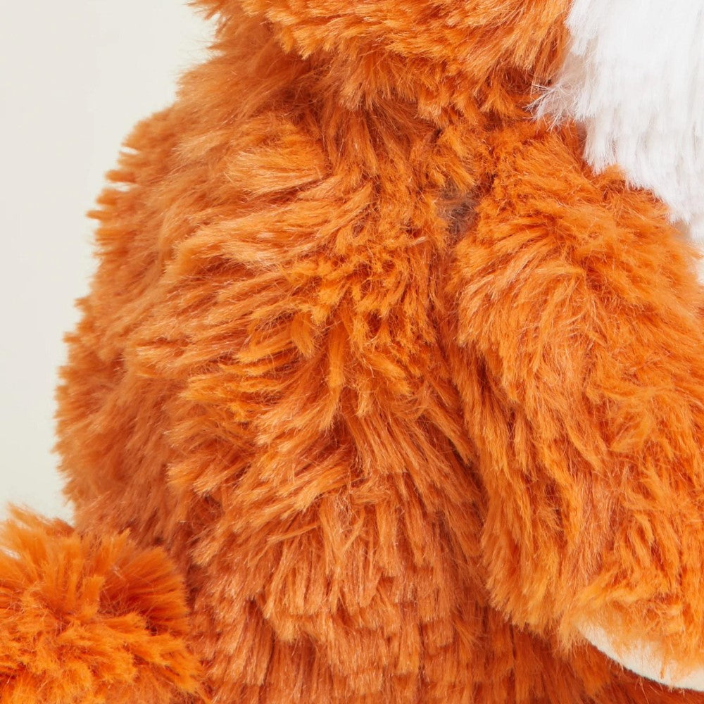 Close-up of orange fuzzy plush fabric with white highlights.