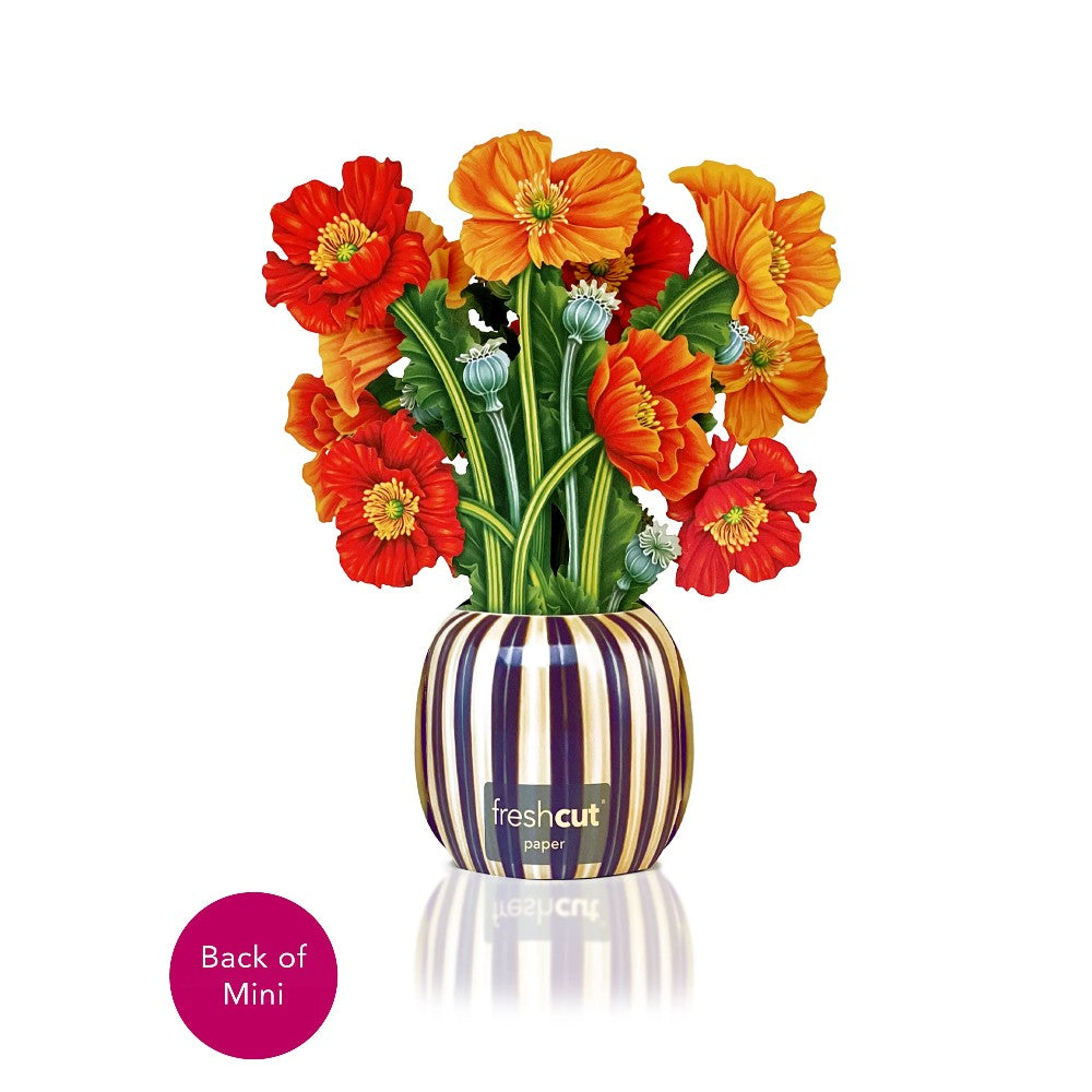 Paper flowers in a striped vase with vibrant orange and red blooms.
