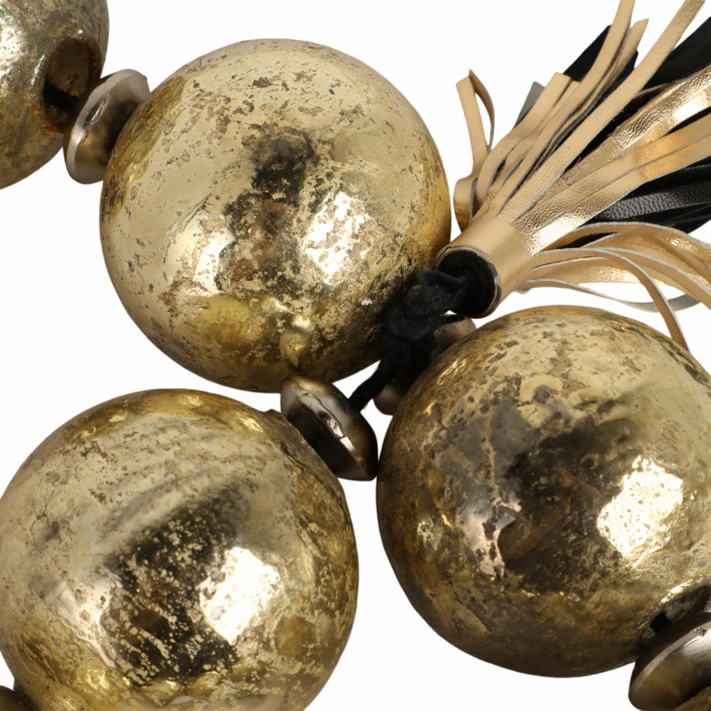 Close-up of rustic golden spheres with tassel.