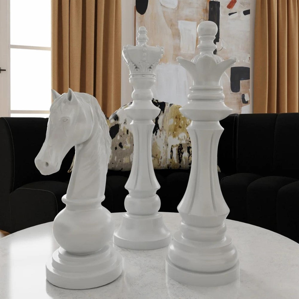 Giant white chess pieces on a table with abstract art backdrop.