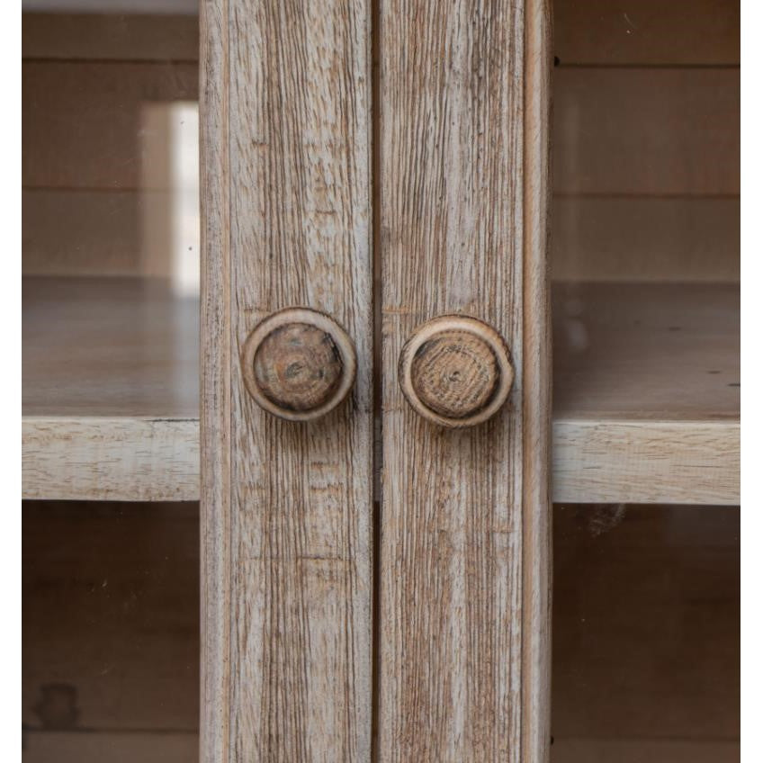 Close-up of rustic wooden cabinet doors with round knobs.
