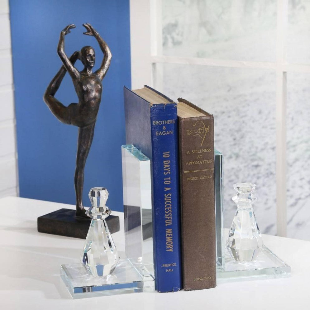 Books and crystal bookends beside a dancer sculpture.