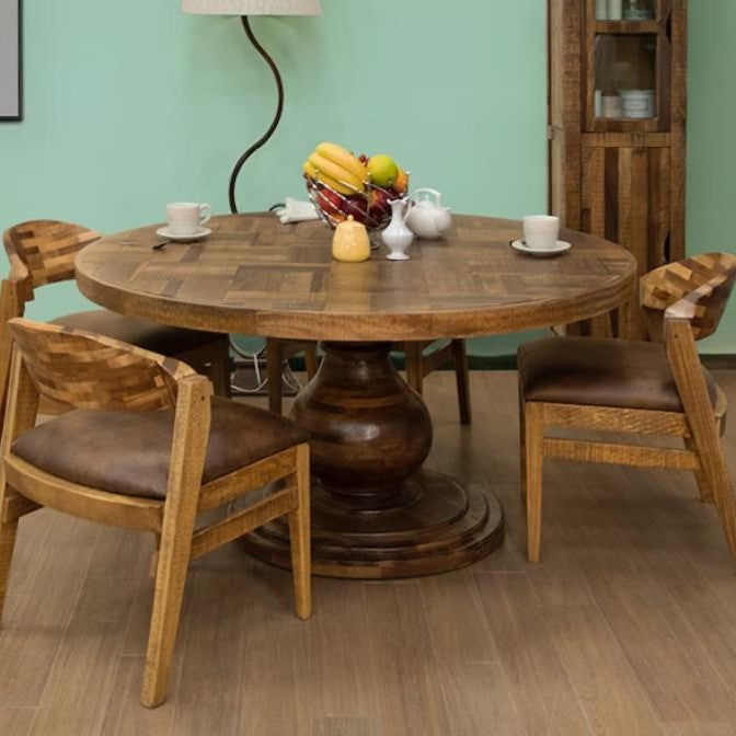 Round wooden table with chairs, fruit bowl, and tea set in a cozy room.