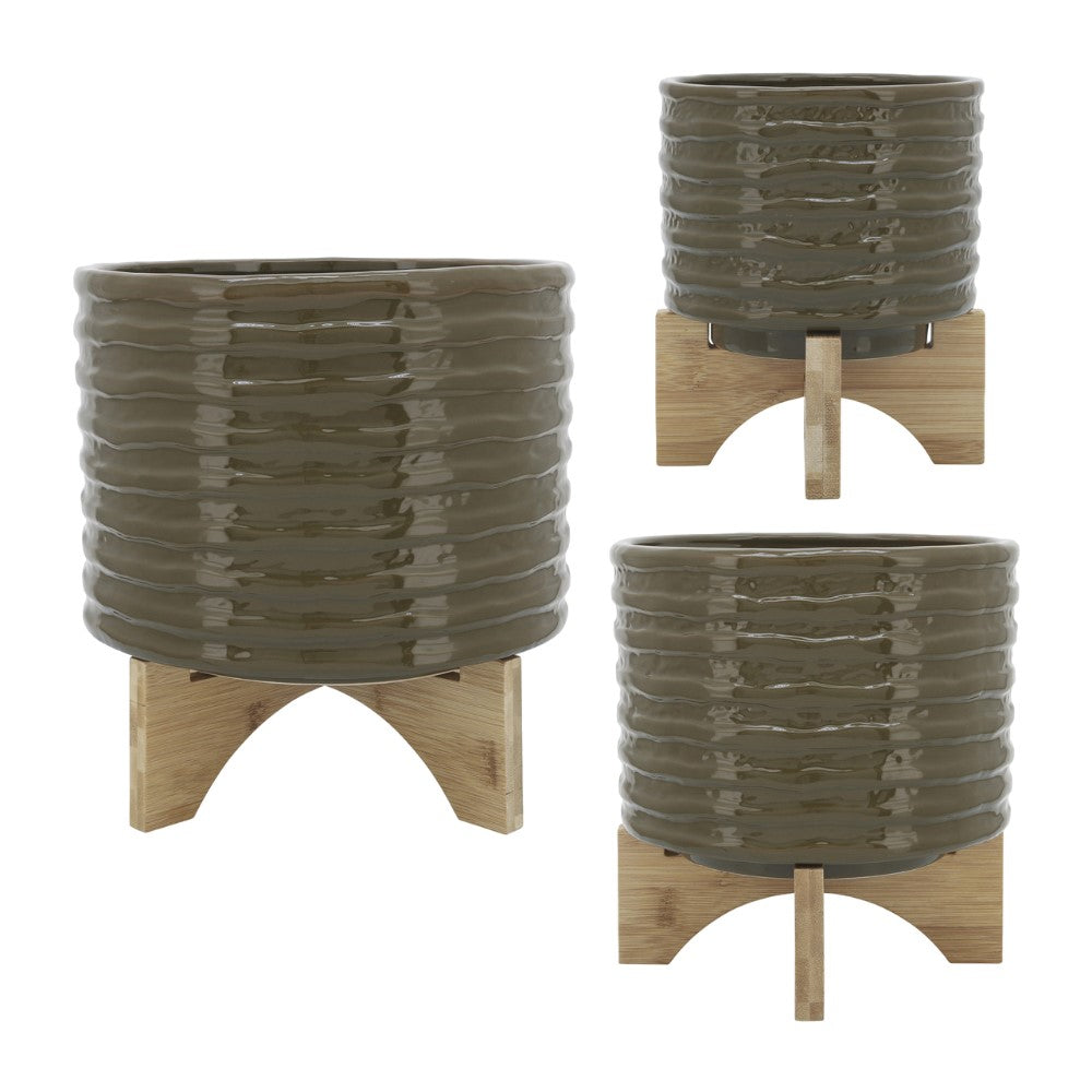 Three green ribbed planters with wooden stands.