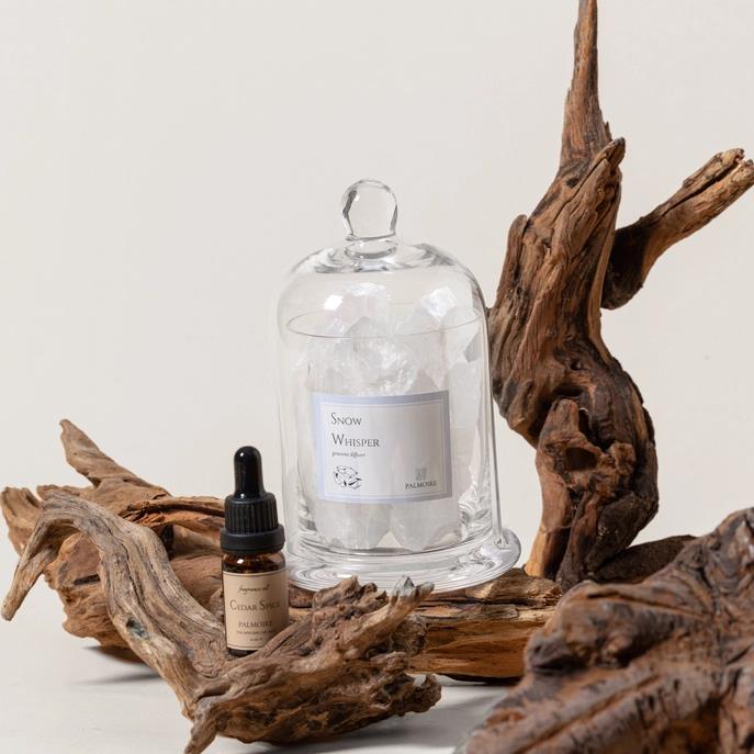 Glass dome over crystals, cedar spice bottle, driftwood.