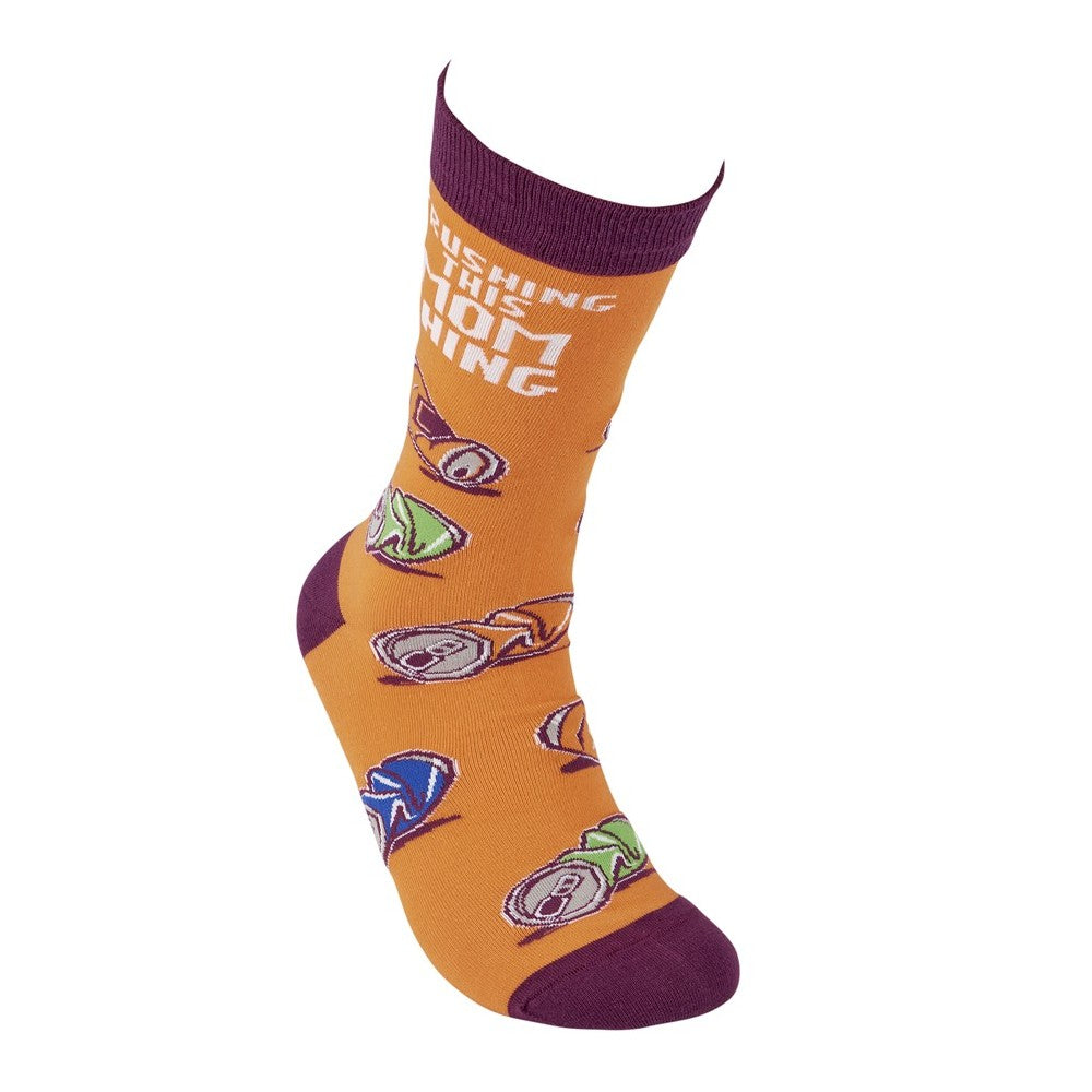 Orange sock with colorful can design and purple accents.