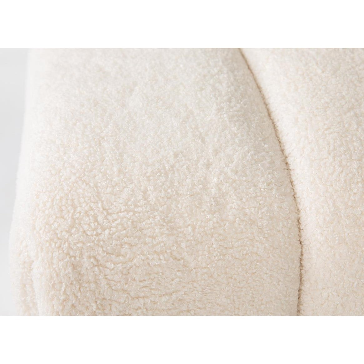 Close-up of a textured, cream-colored woolly fabric surface.