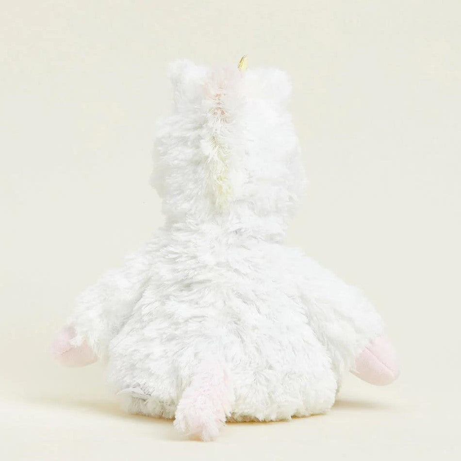 Fluffy white plush unicorn sitting, viewed from behind.
