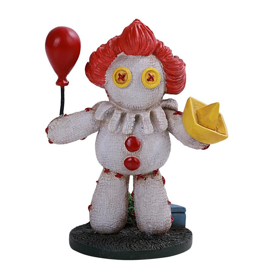 Voodoo clown figure holding balloon and paper boat.