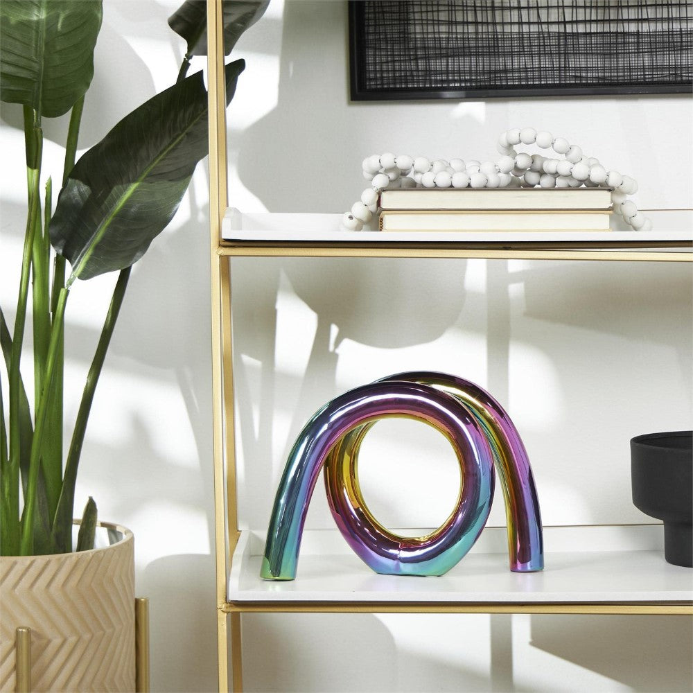 Colorful sculpture on shelf near plant with books and decorative beads.