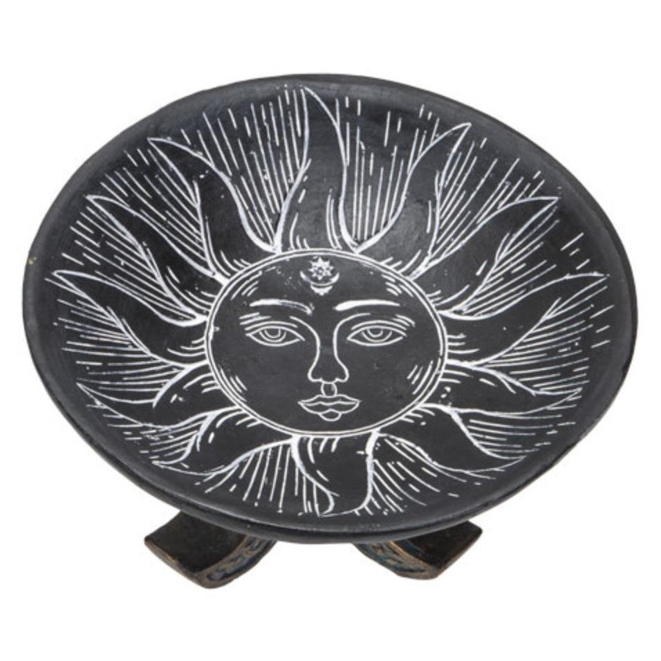 Black sun-themed ceramic plate with a face design.
