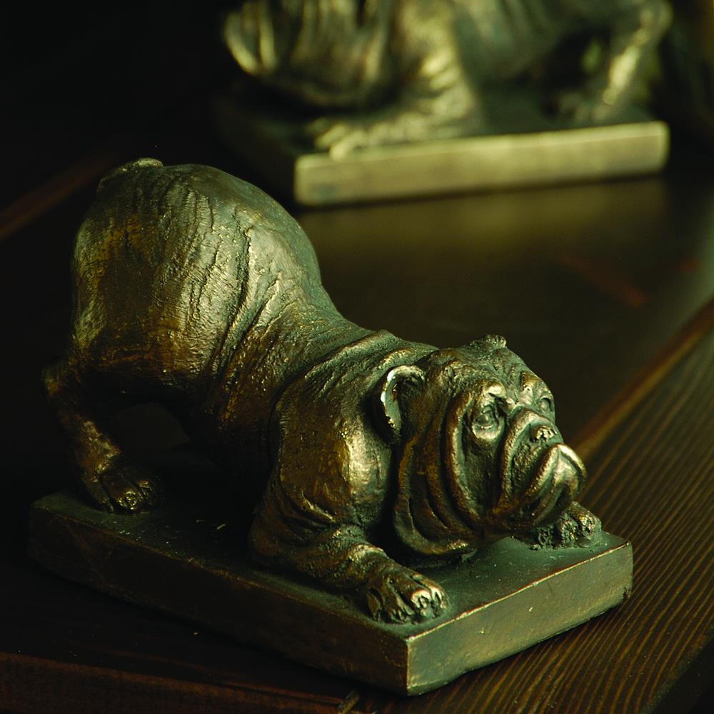 Bronze bulldog sculpture on a wooden surface.