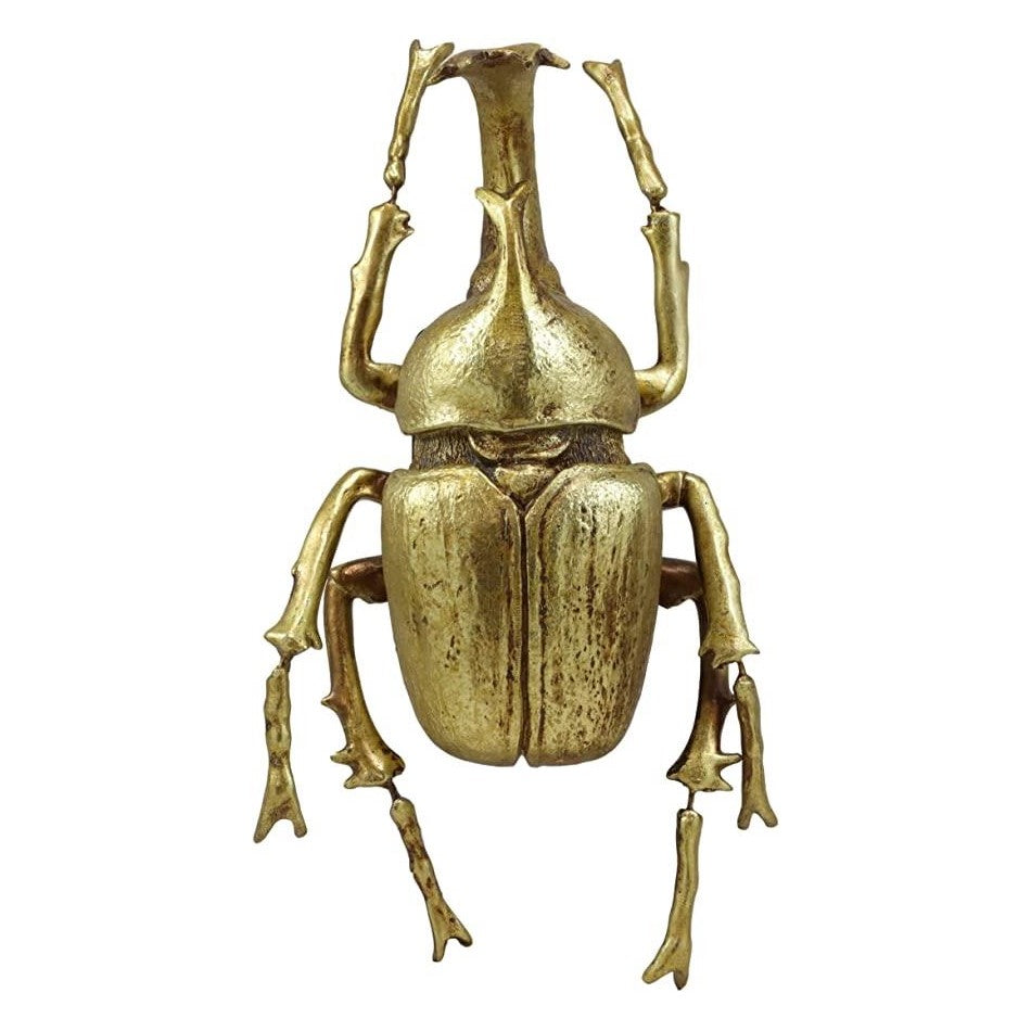 Golden beetle sculpture with detailed texture and outstretched legs.