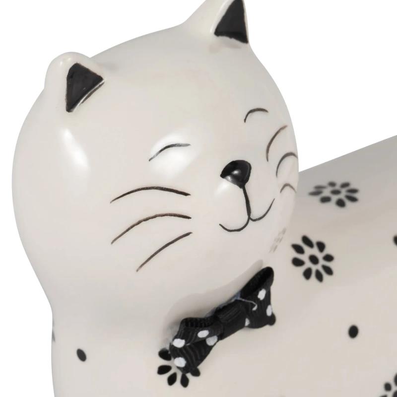 Ceramic cat figurine with a black bow tie and flower patterns.