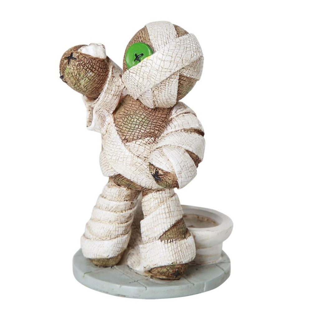 Mummy doll figure with button eye on a stand.