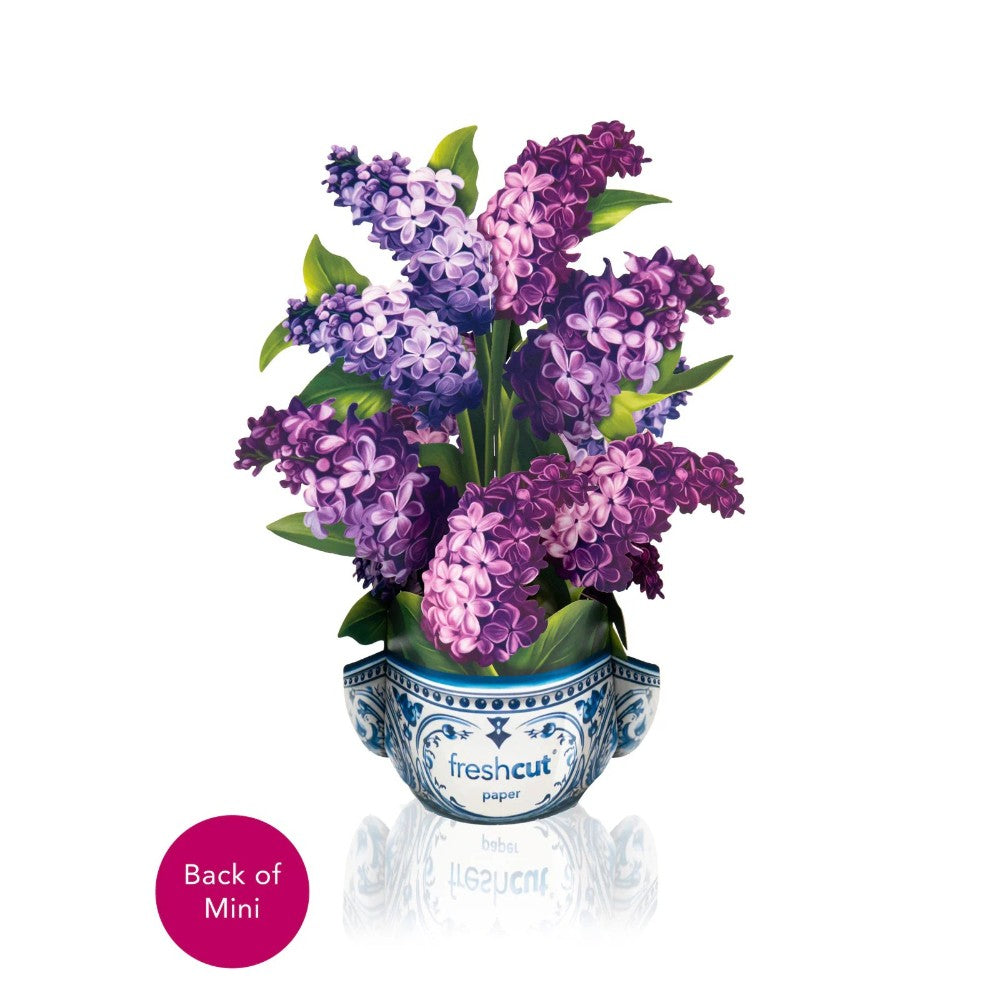 Purple lilac paper flowers in a decorative vase.