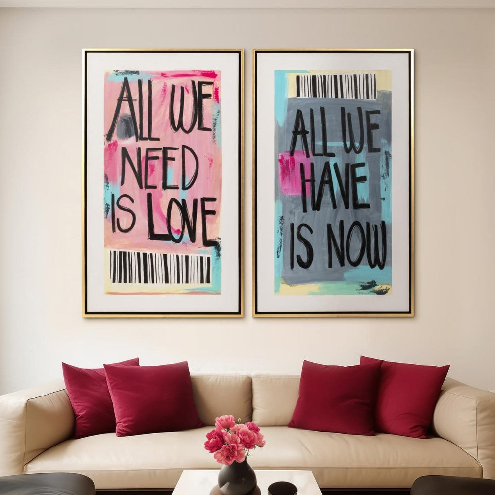 Two framed artworks above a beige sofa with red pillows and flowers.
