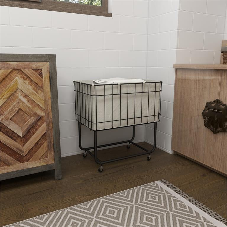 Wire laundry basket on wheels in a cozy room corner.