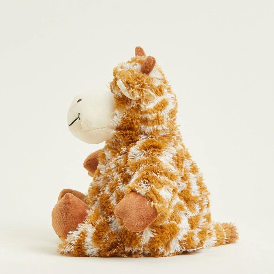 Fluffy giraffe plush toy sitting on a plain background.